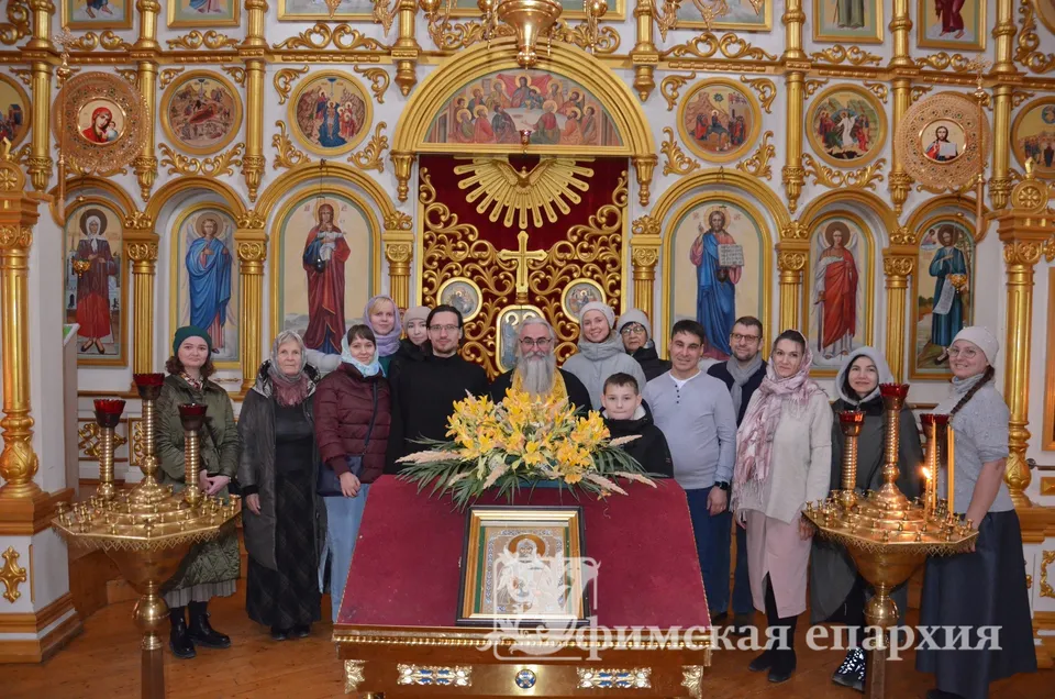 Группа молодых людей стоит перед иконостасом во время экскурсии по храму